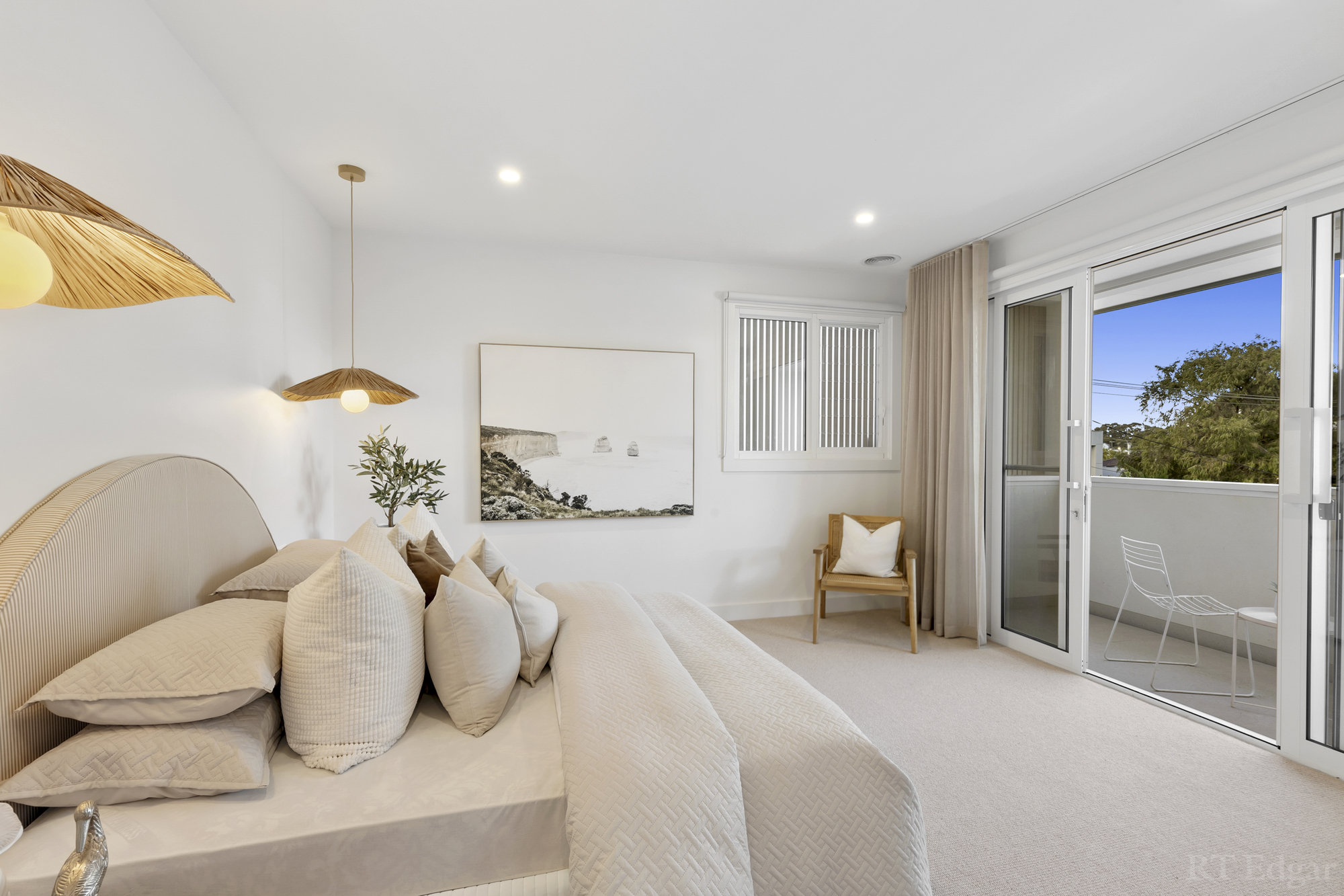 Bright bedroom with soft neutral finishes and access to a private balcony