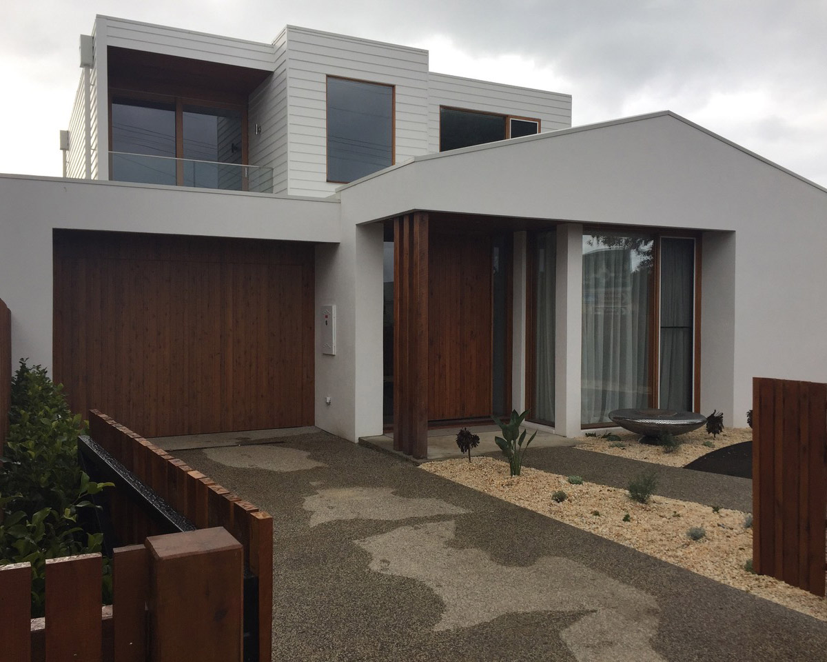 Contemporary two-storey home with pale render and timber detailing