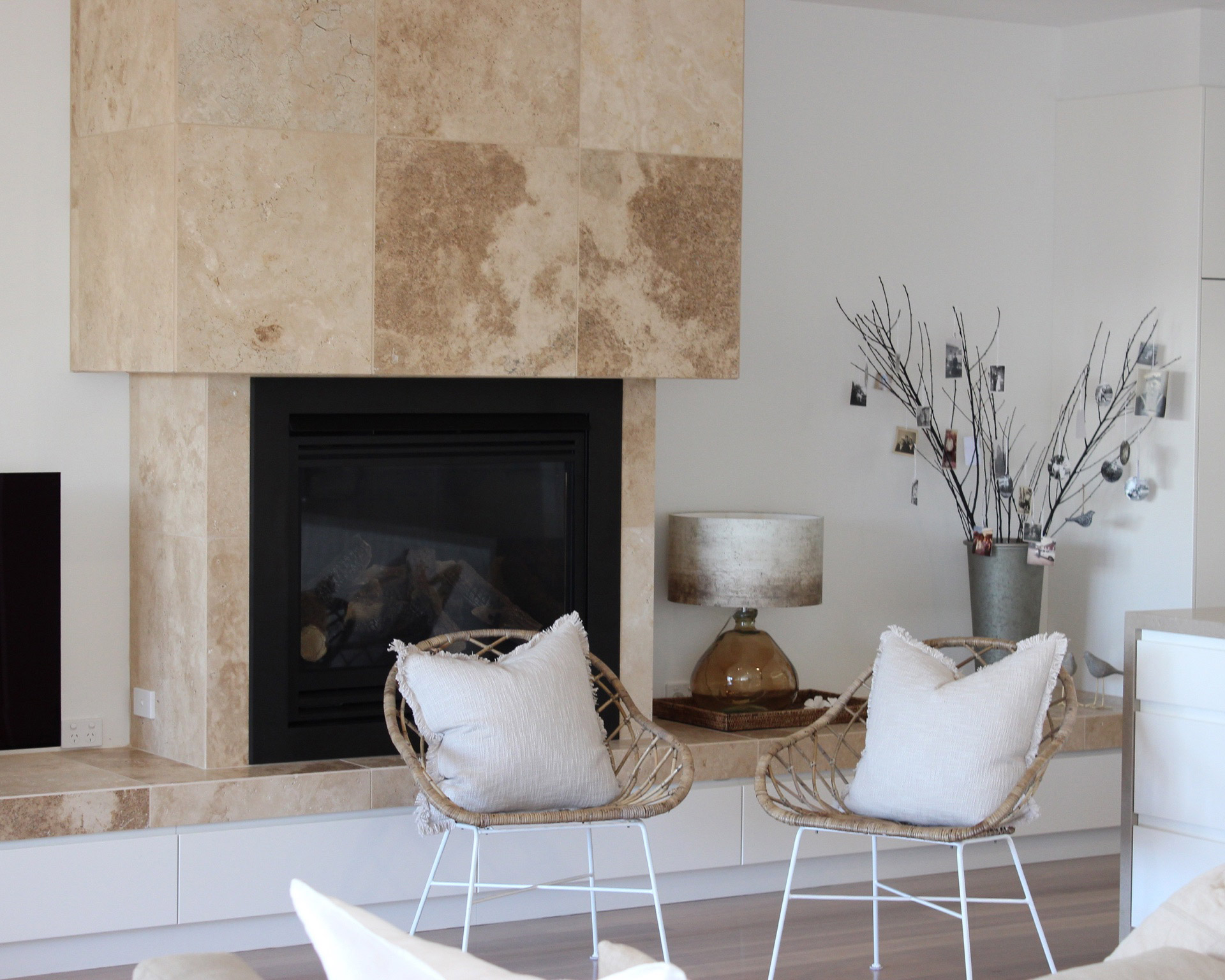 Bright living room with stone fireplace and woven chairs
